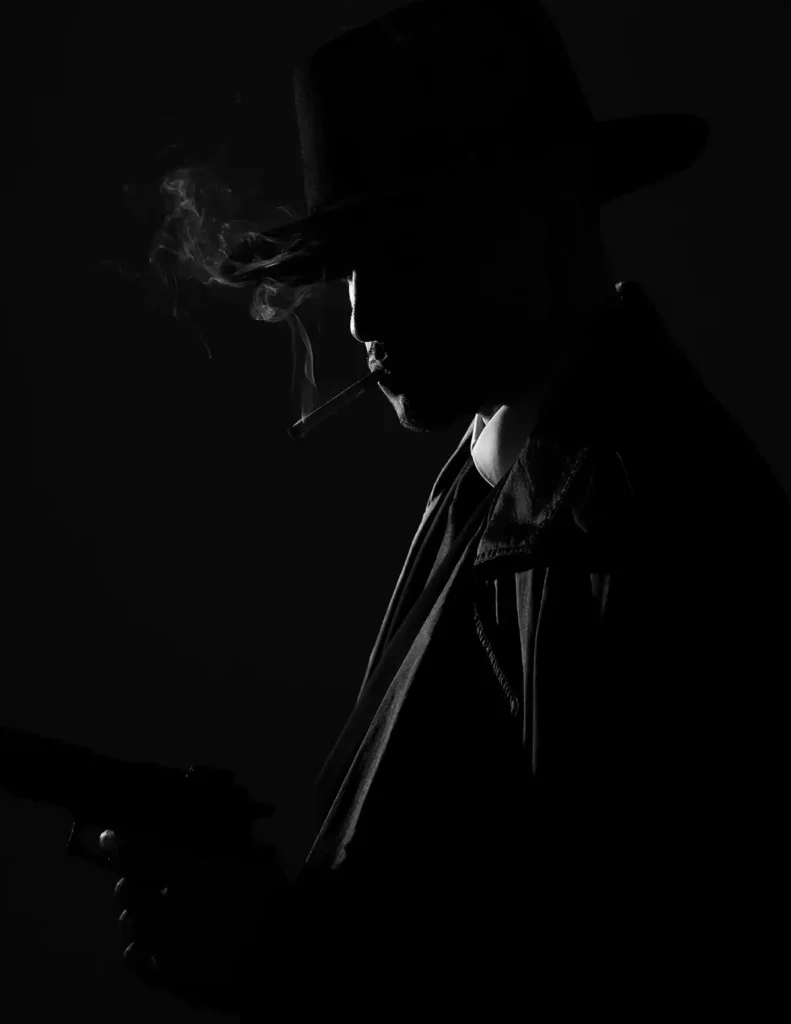 Noir-style silhouette of a mysterious mafia character wearing a fedora and suit, creating a cinematic atmosphere for Mafia party games and social deduction events.